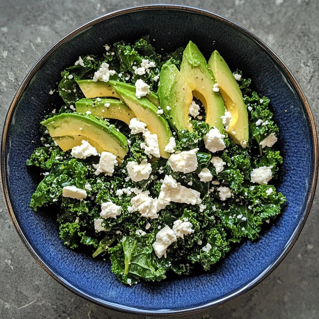 Kale-Salat mit Avocado und Ziegenkäse auf einem Teller angerichtet.